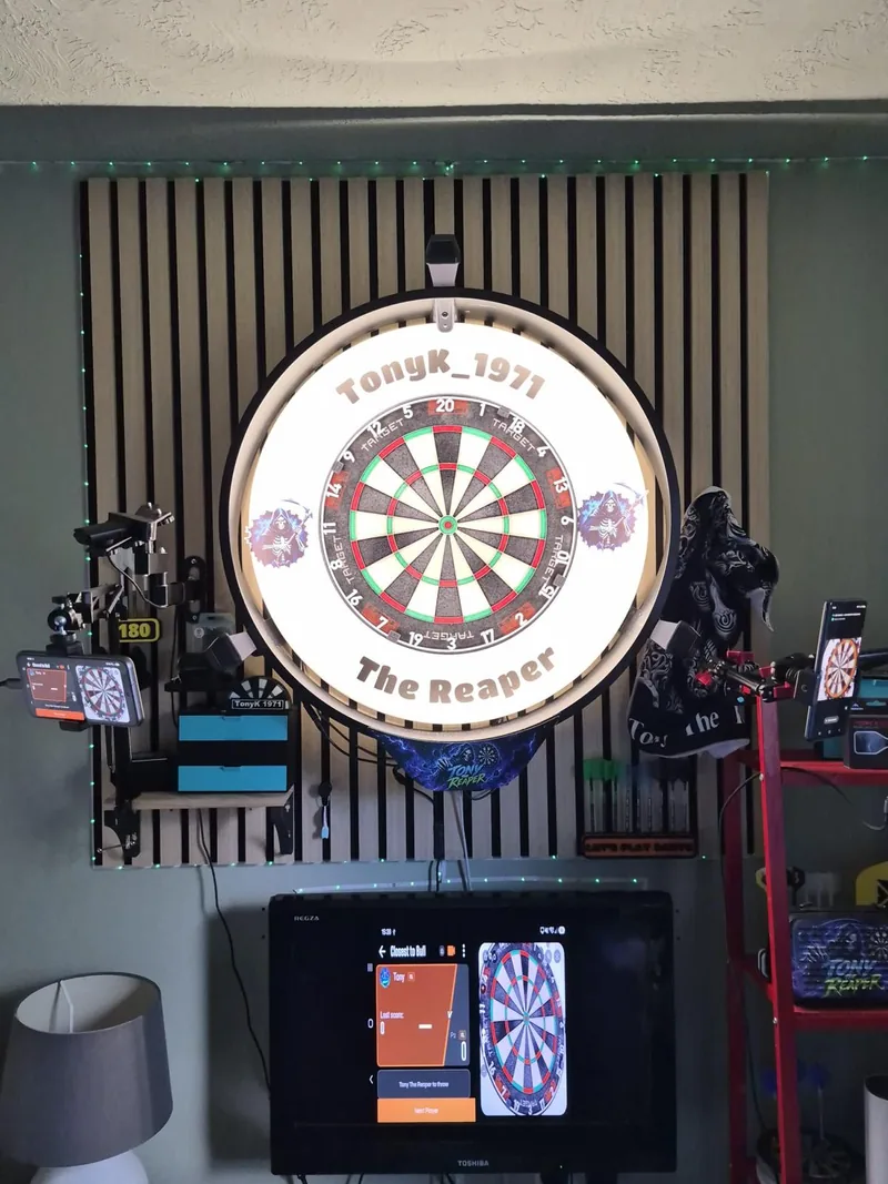 A custom-branded dartboard with the DartsKEY scoreboard on a monitor underneath